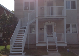 Front of a duplex with staicase, railing and columns2