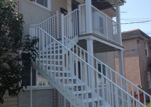 Front of a duplex with staicase, railing and columns